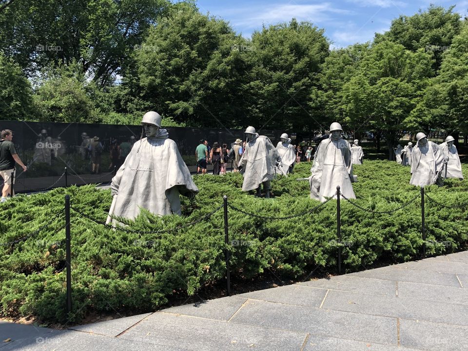 Stone statues of soldiers at the Korean War Memorial in Washington, D.C. on a summer day 