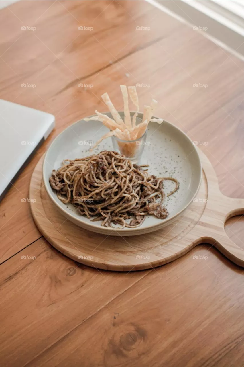 Close-up of noodles in plate on table. Food. Eat. Lunch. Breakfast. Snacks. Dessert. Photography. Aesthetic. Isolated background. Pastel colors. Table. Wood motifs. Cafe. Noodle. Delicious. Tranquil.