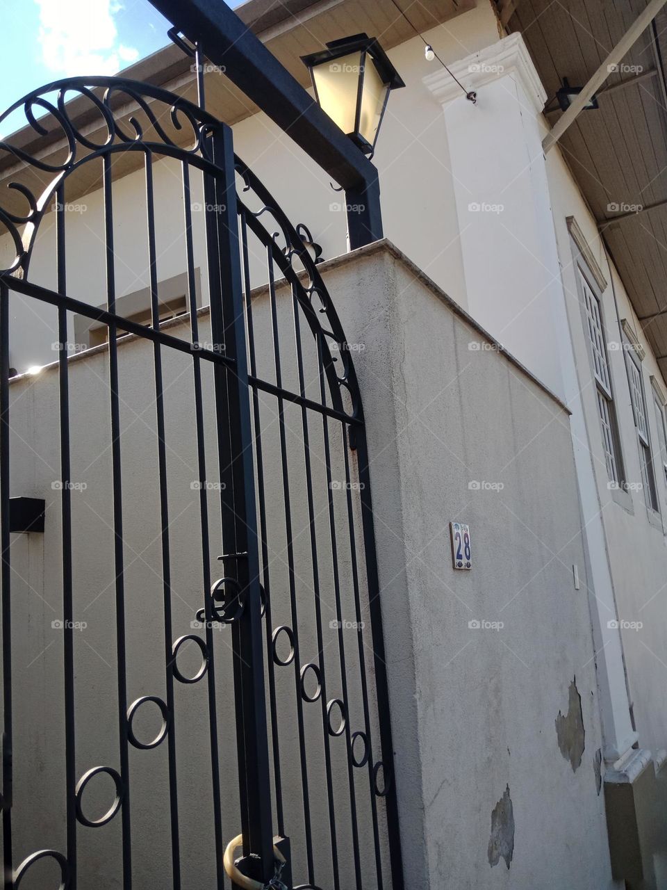 Old house with a locked gate and a light