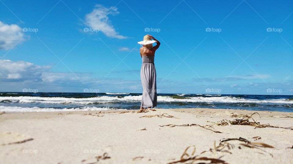 Rear view of a woman standing on beach