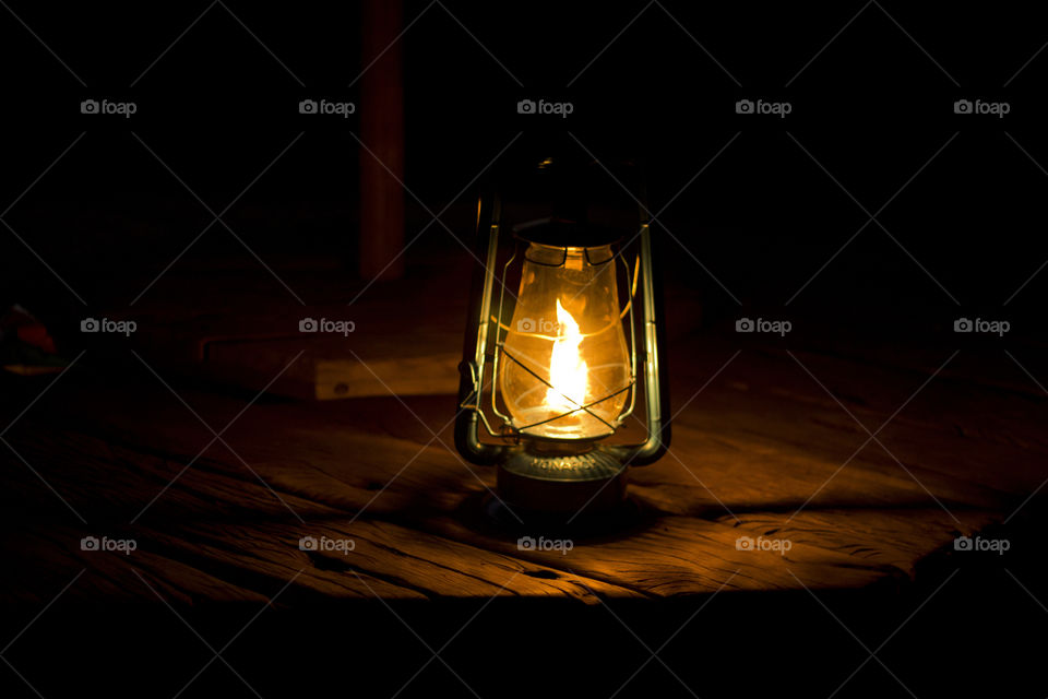 oil lantern burning on a wooden table