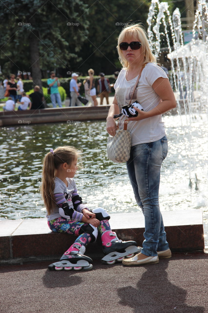 мама с дочкой у фонтана в парке