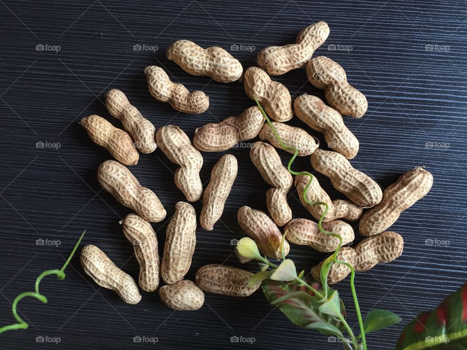 Some of unpeeled peanuts on dark wooden background  