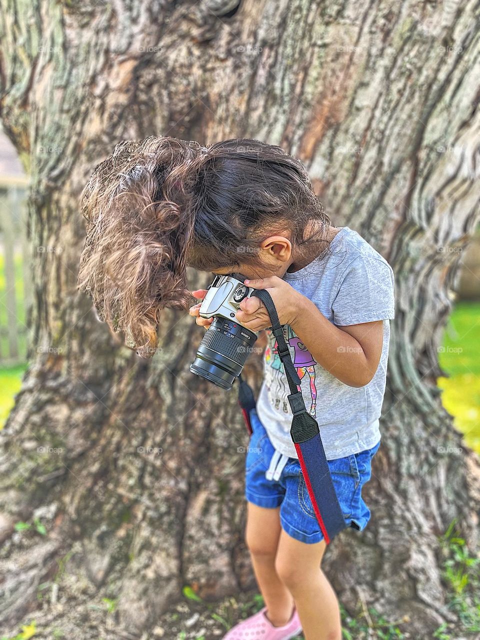 Toddler photographs summer, toddler with Canon camera outside, toddler takes pictures of the summer, toddler girl with camera enjoying the warm weather 