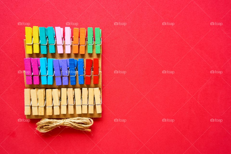 Colorful wooden clips on red background 