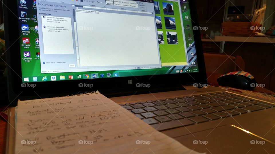 Journalist's notebook laid out in front of reporter's laptop with breaking news.