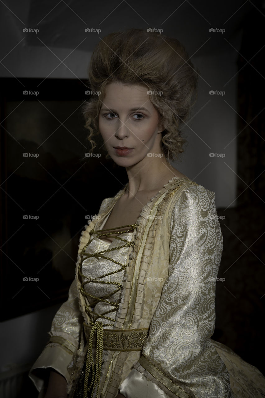 One of a set of photos taken in a 17th century house that is now a restaurant and hotel. The look is based around Marie Antoinette with long luxurious dress and hair styled high. Makeup was very pale and finished using baby powder