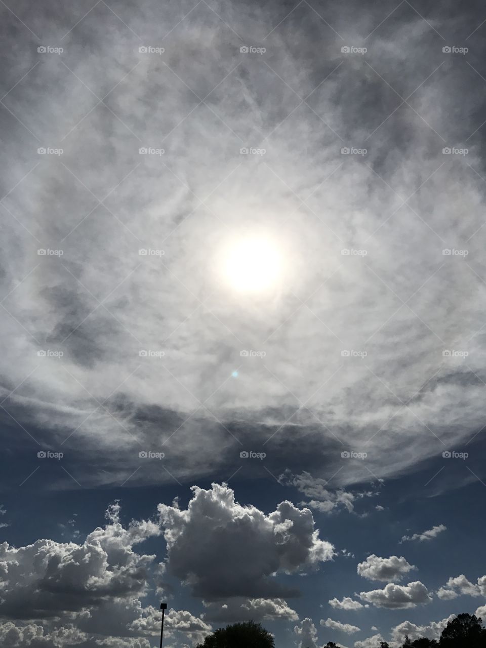 Dramatic skies in Prescott, Arizona. Deep, vivid, Crayon blue sky with an intense sun breaking through the clouds. 