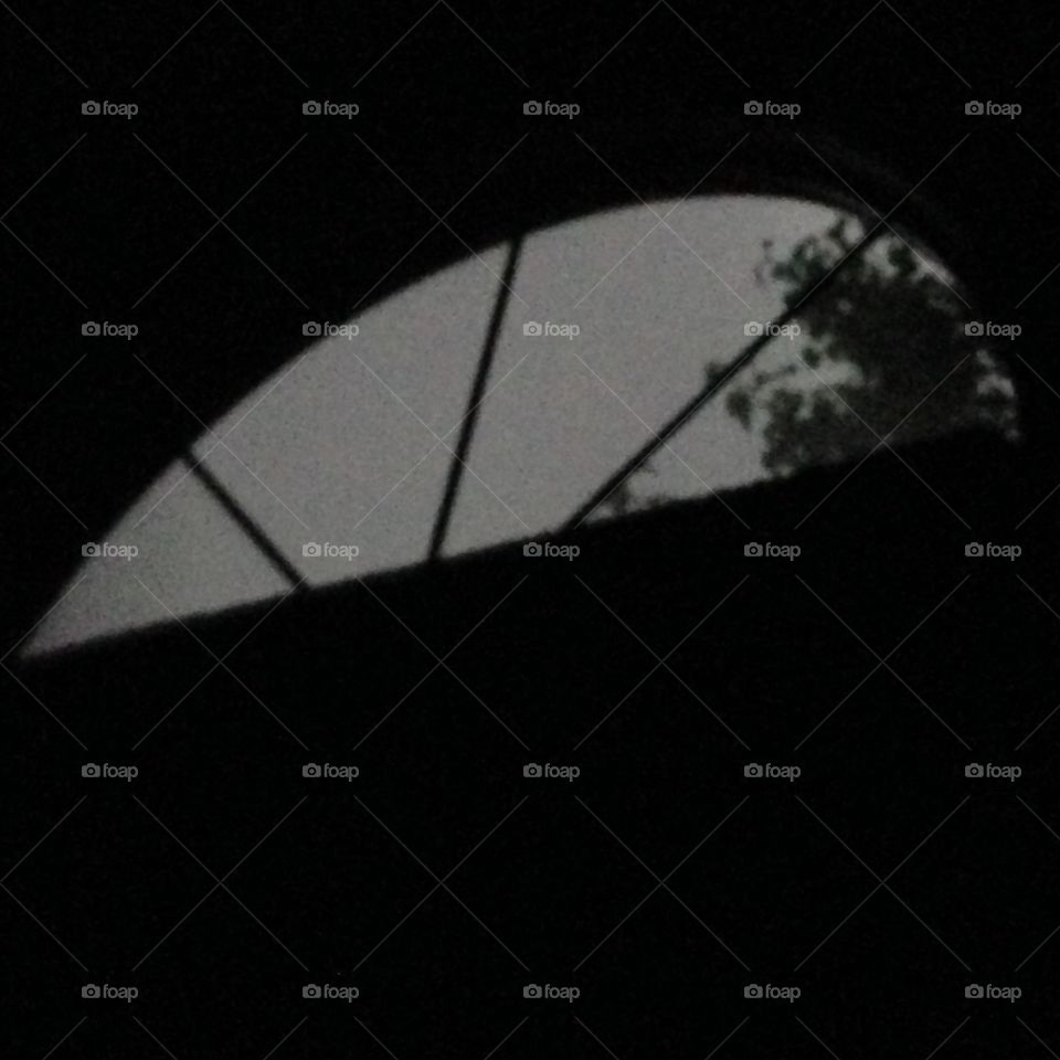 Nighttime, laying in bed looking up at my window during a thunderstorm