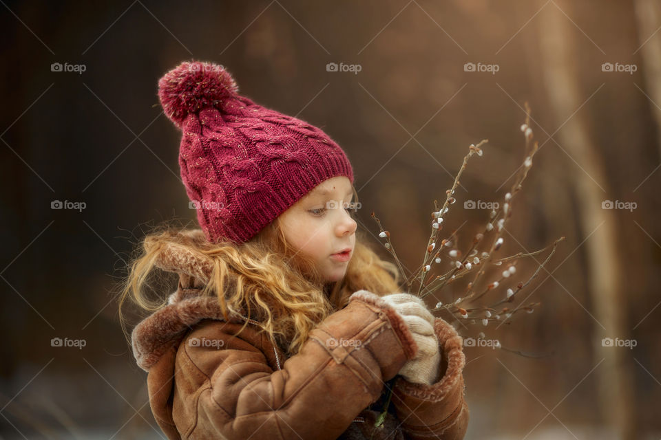Little girl with willow branches in hands