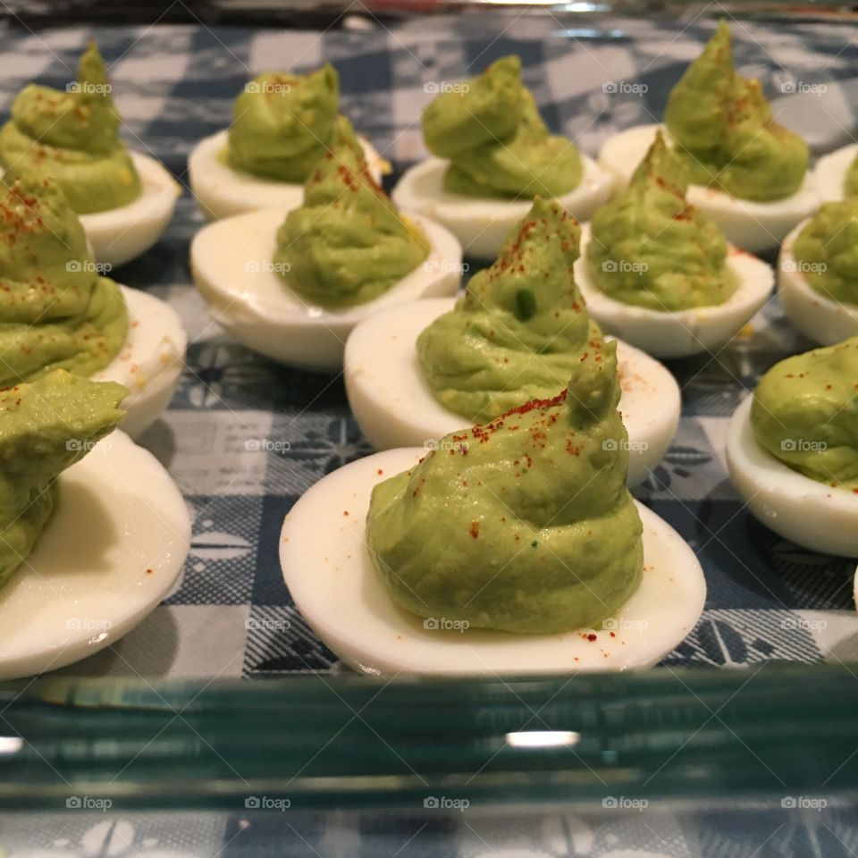 Avocado deviled eggs, with paprika sprinkled on top. 