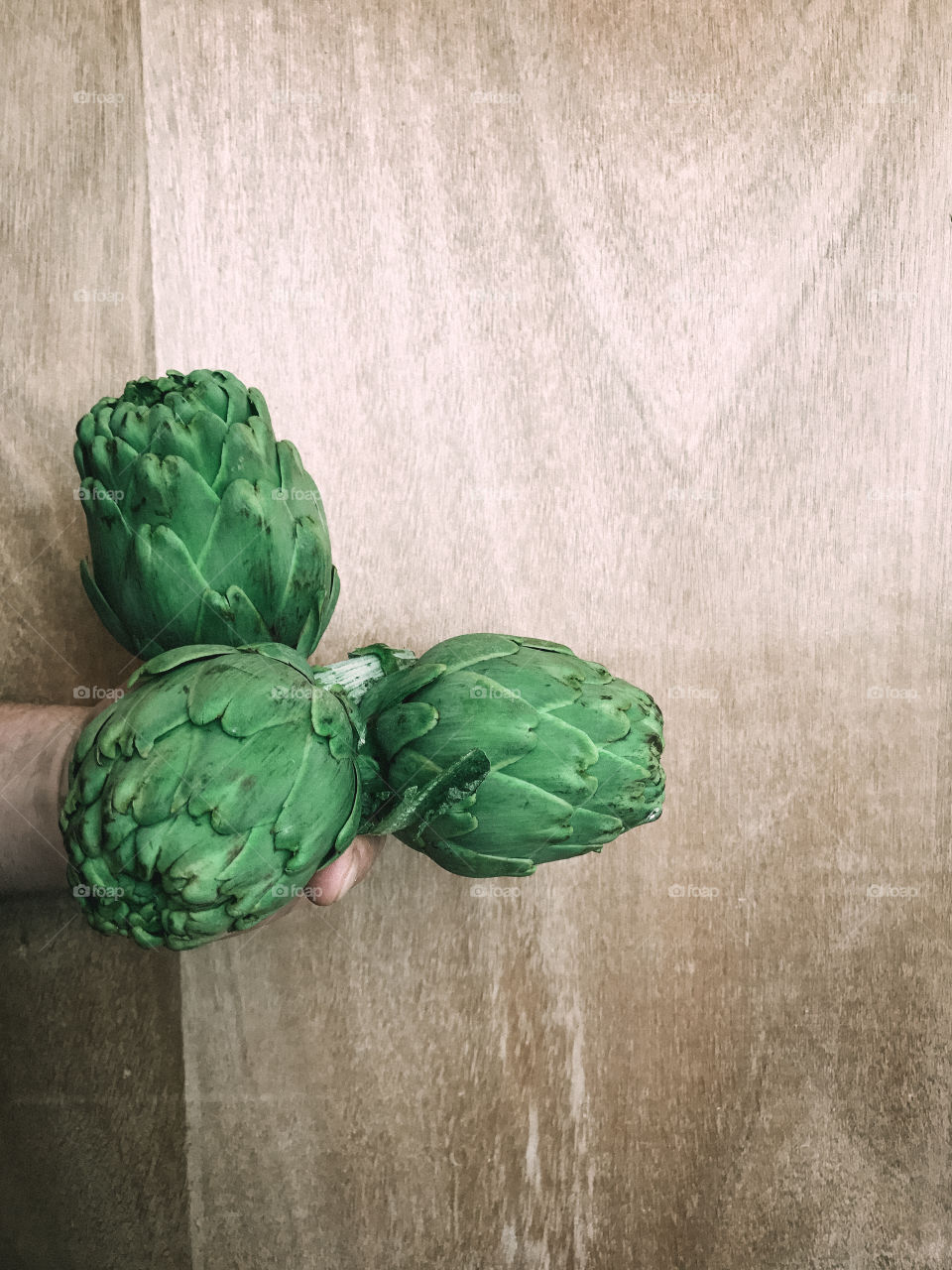 Hand holding artichokes 