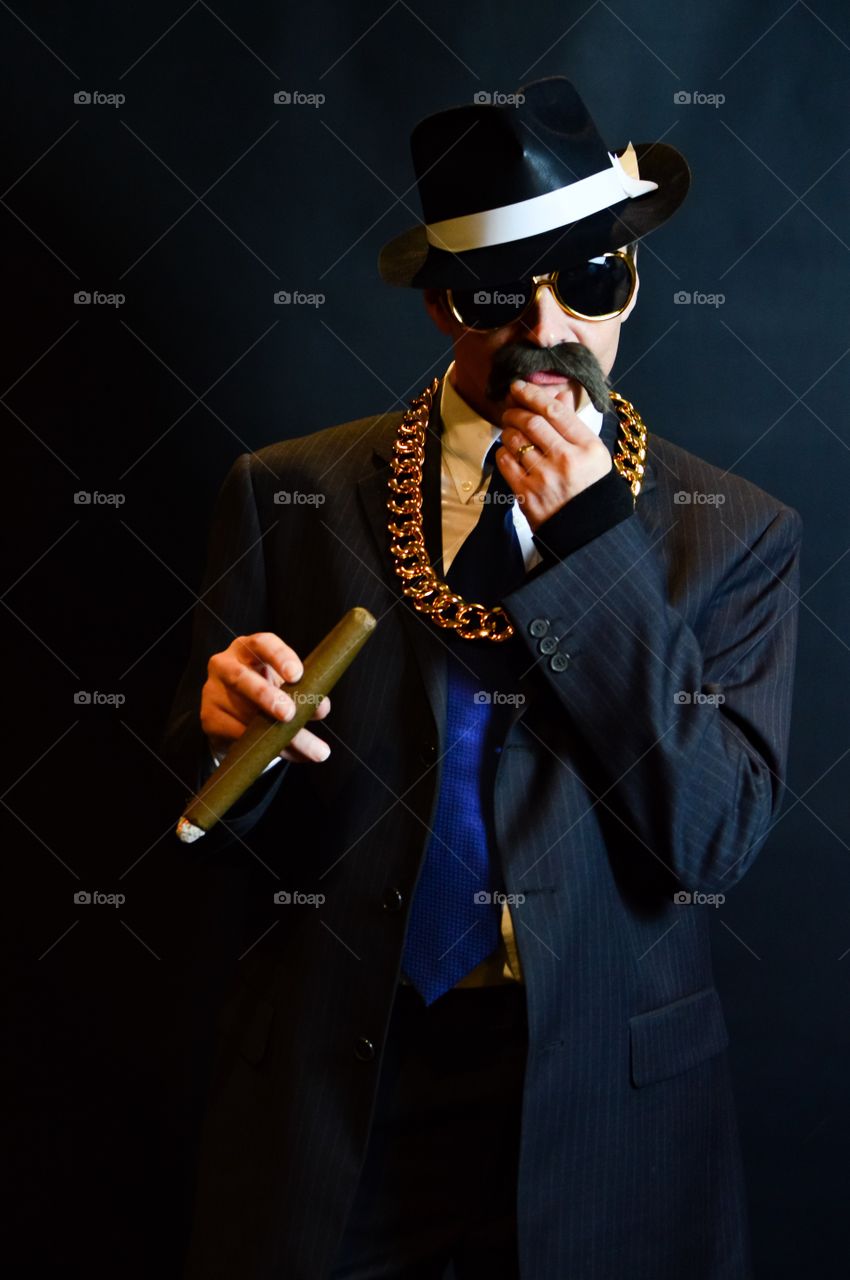 Man smoking cigar on black background