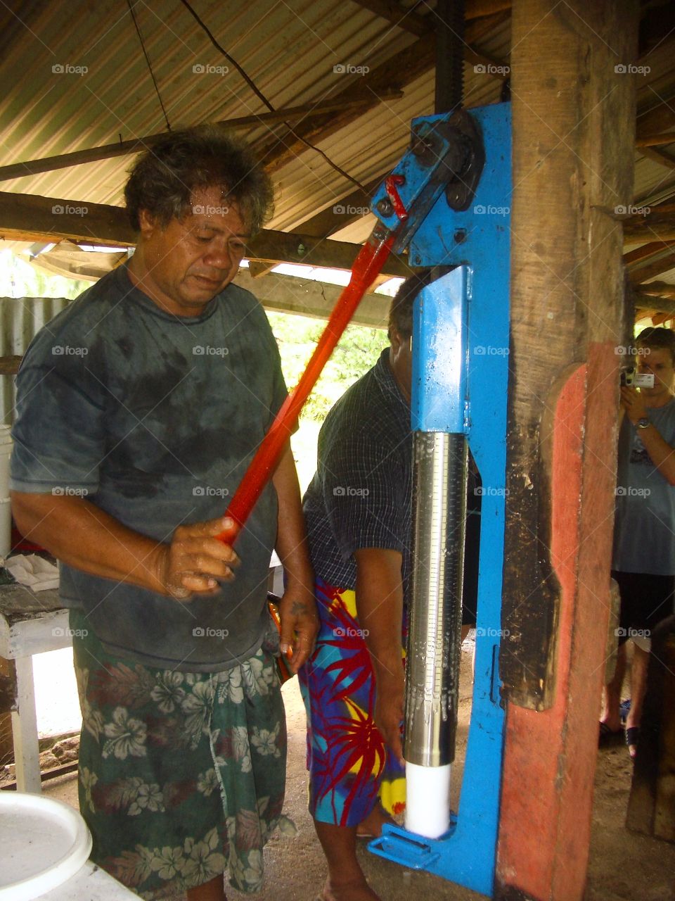 Man operating coconut oil press