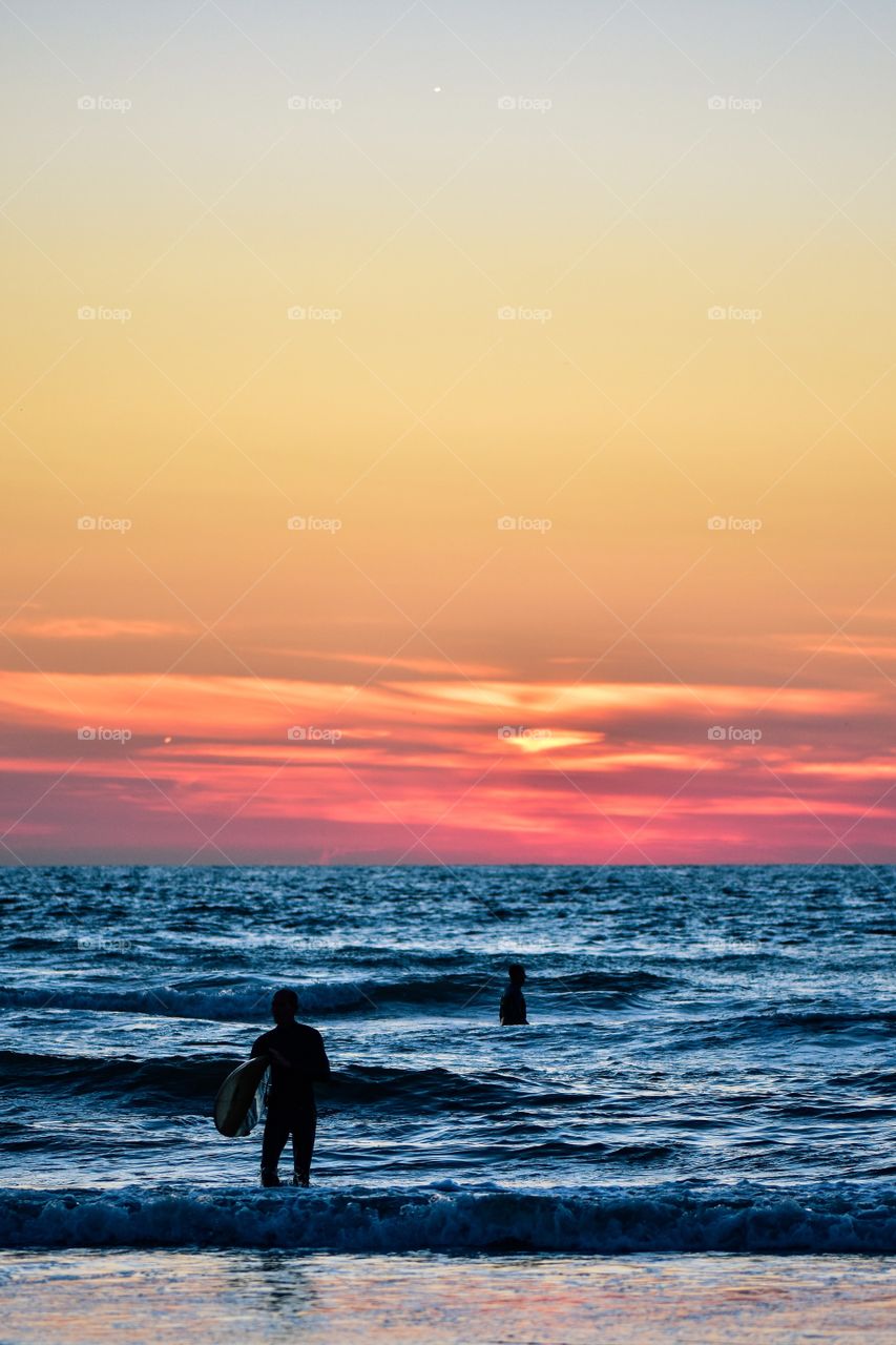 Surfers at sunset