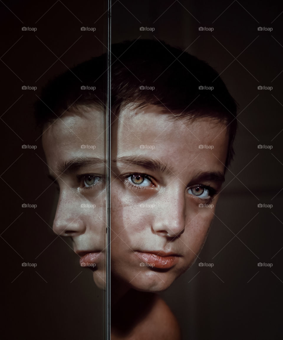 Close-up portrait of boy reflecting on mirror