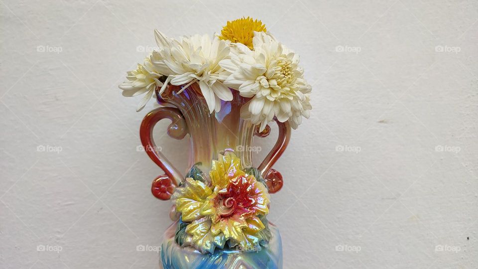 Beautiful white flowers in a colourful flowerpot with a flower sculpture, Flowers in a vase, colourful vase, white flowers in a vase