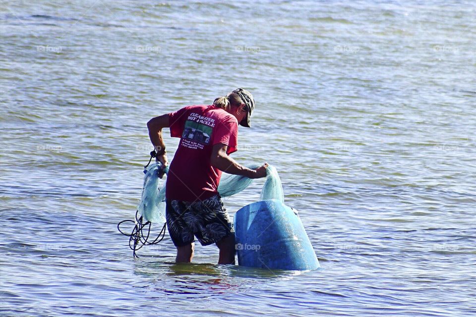 Summertime fisherman casting his net.