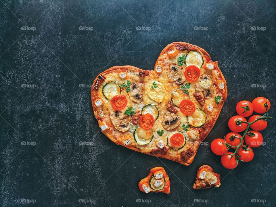 Delicious vegetarian pizza with tomatoes, cheese and herbs on black background close up. Top view. Flat lay. Love to cooking.