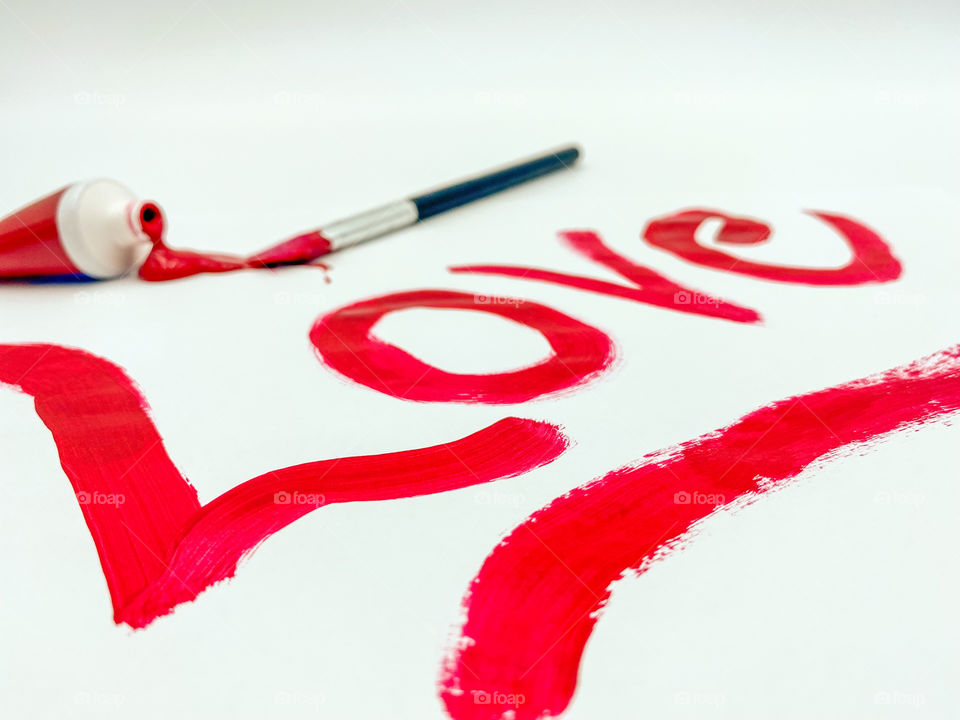 Love written in red paint on white background 