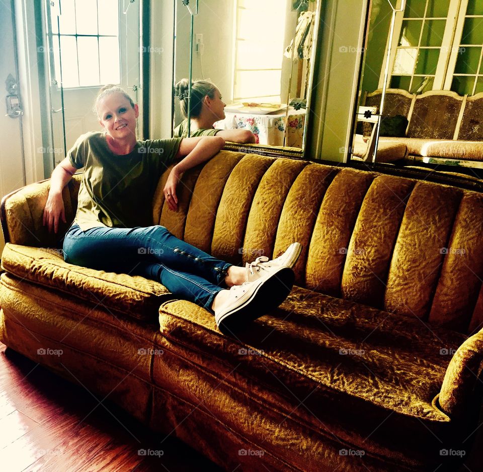 Happy woman sitting on sofa in house