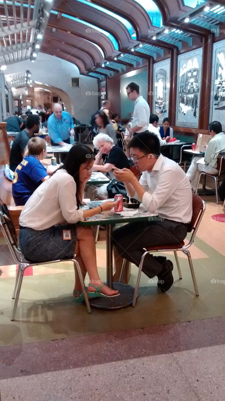 People on cell phones at lunch. at food court at lunch