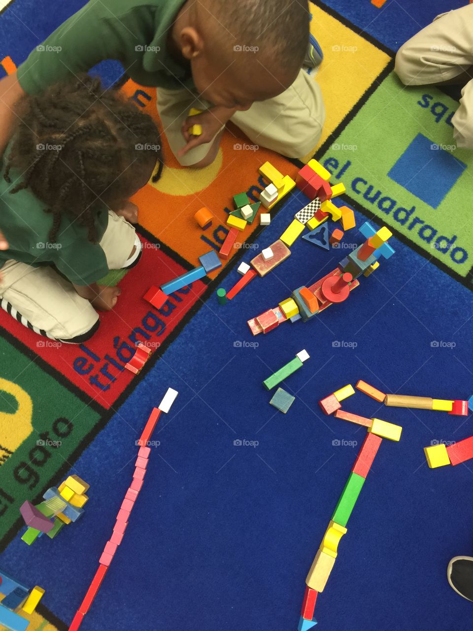 School . Children sitting on rug playing and learning Spanish words