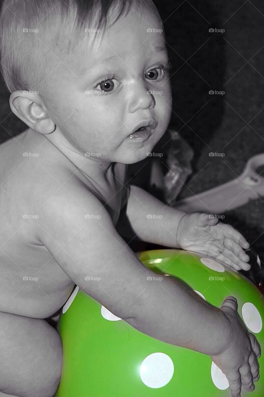 Baby boy with a green balloon