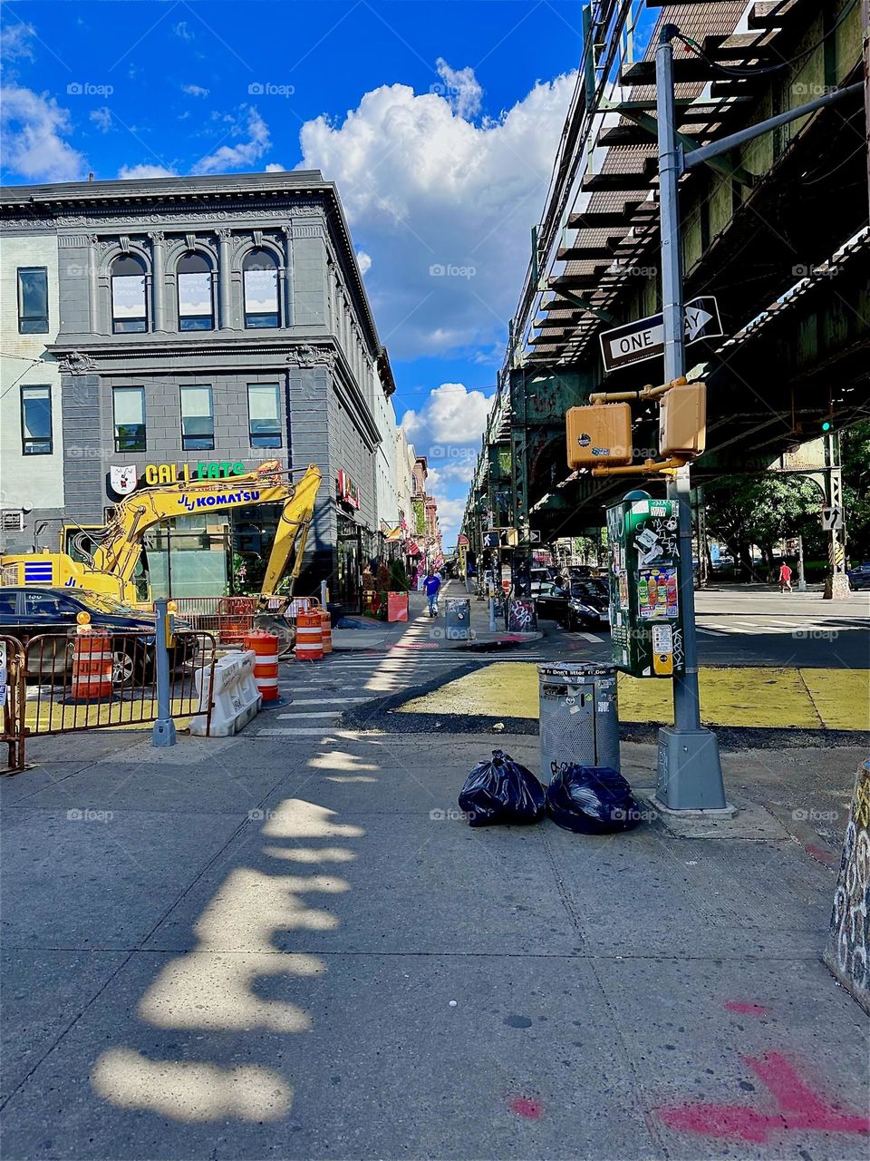 This is “Broadway” in “Bushwick”, Bklyn with the “M” train overpass running overhead. Its multifaceted industrial structures cast interesting light and shadow patterns on the sidewalk far into the distance. 2024. Hypnotic Productions