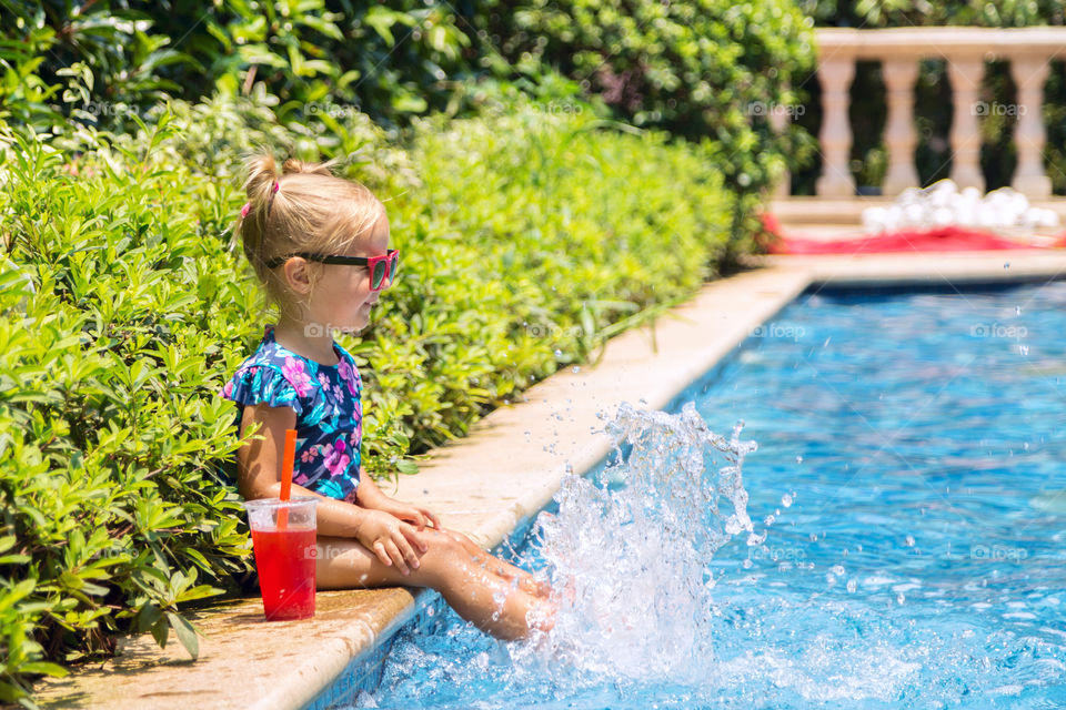 Happy kid playing in swimming pool 
