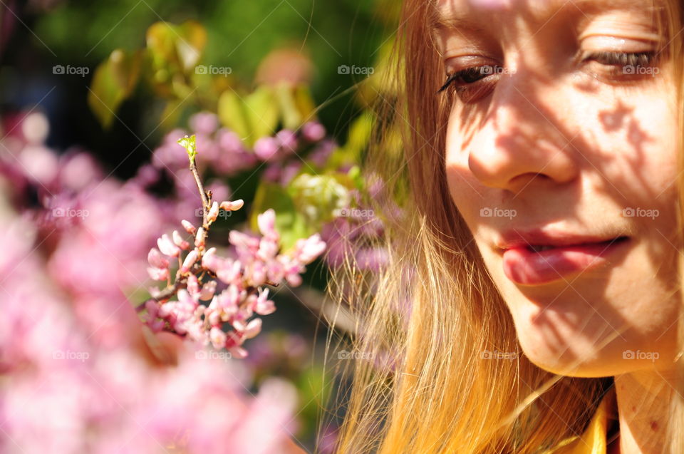 Close-up of a pretty woman near fresh flowers