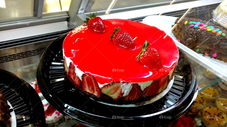 Bolo de morangos com uma linda cobertura vermelha.