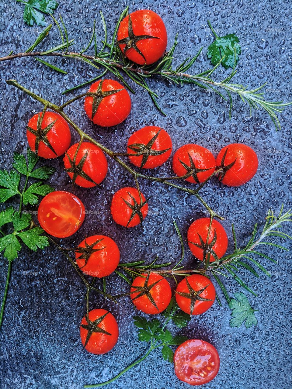Cherry tomatoes with seasonal herbs lie on the surface.