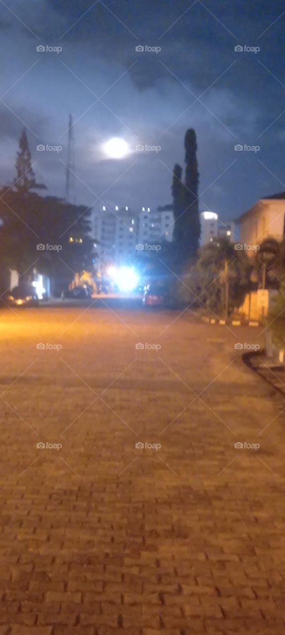 Viewing the beautiful full Moon in the night sky on the street