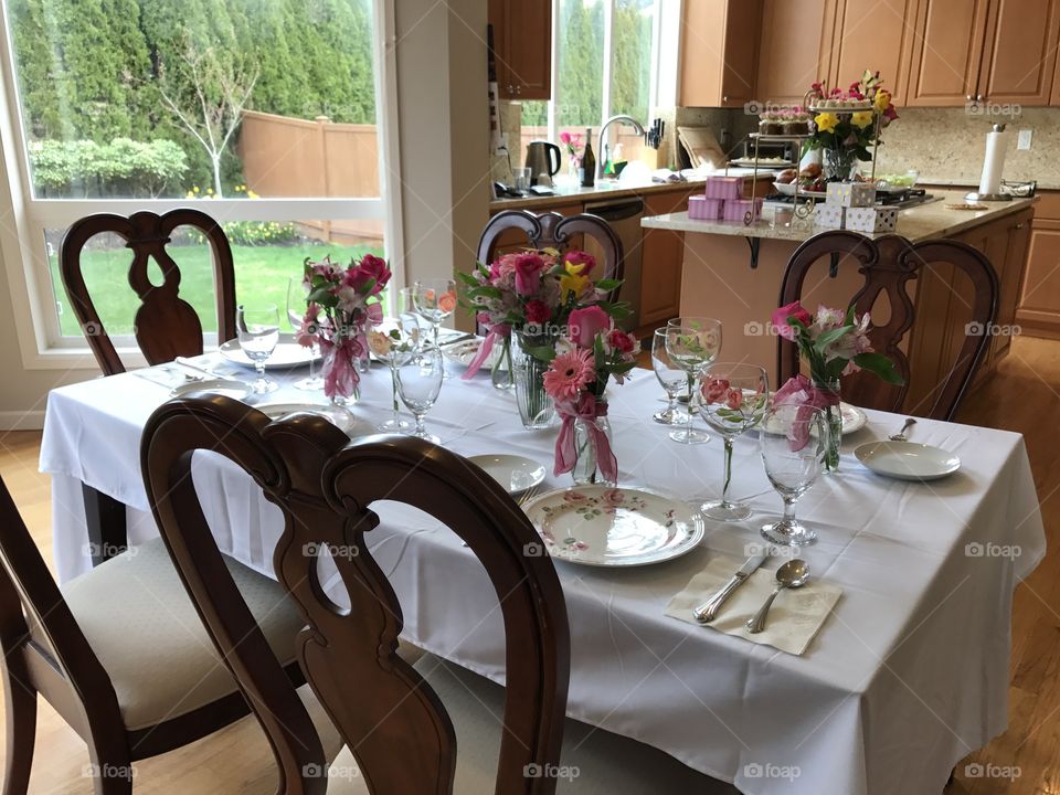 Afternoon tea party with delicious food, chairs, flowers plate setting 