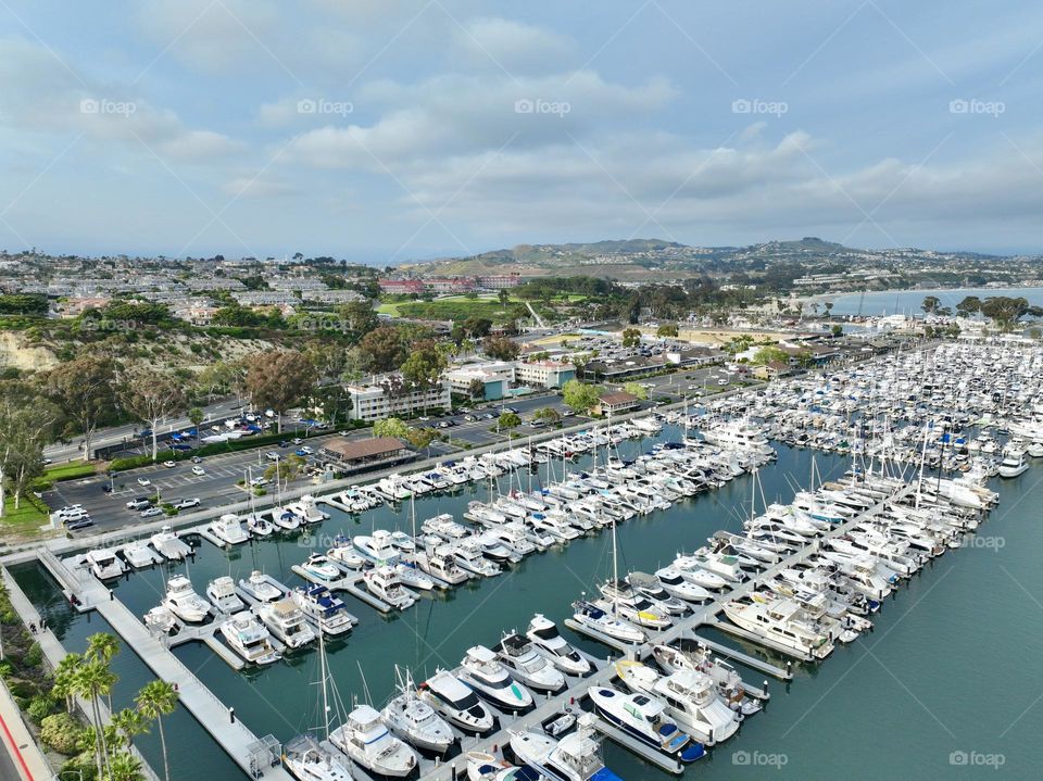 A sunny day in the famous dana point harbor where all the boats, sailboats, yachts, and all watercraft come into this famous harbor to dock before heading back out to sea 