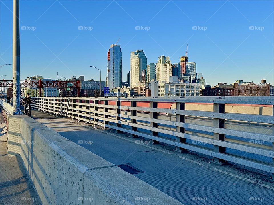 This is the pedestrian and the bicycle lane of the “Pulaski Bridge” at “Newtown Creek” that connects “Greenpoint”, Brooklyn to LIC, Queens in the direction in which we are heading. 2024. Hypnotic Productions