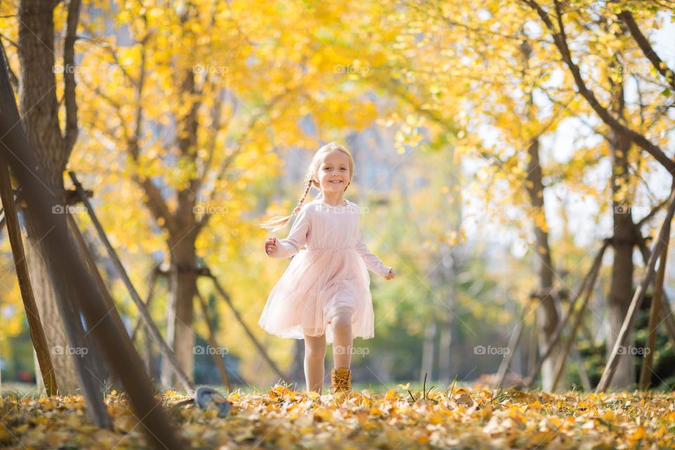 Girl running in park at autumn 