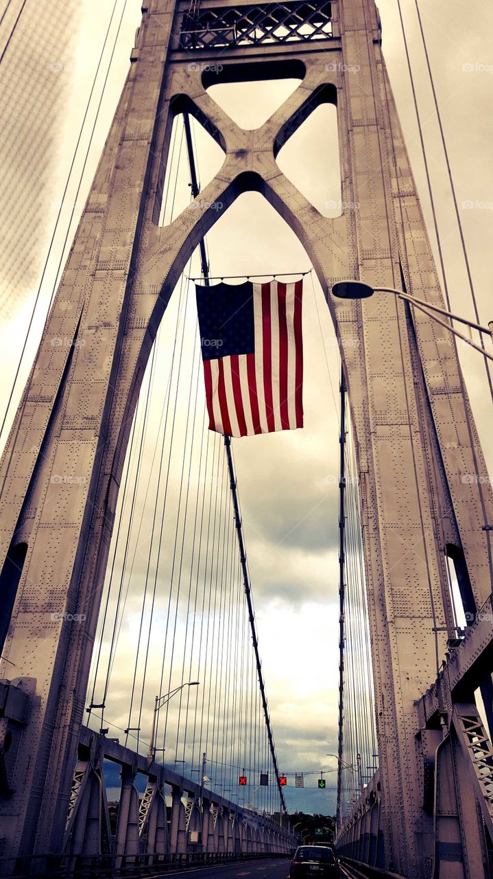 The American flag flies high on the Hudson Bridge