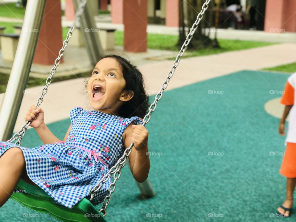 Girl shouting And looking upside while swinging,girl fear of swing.