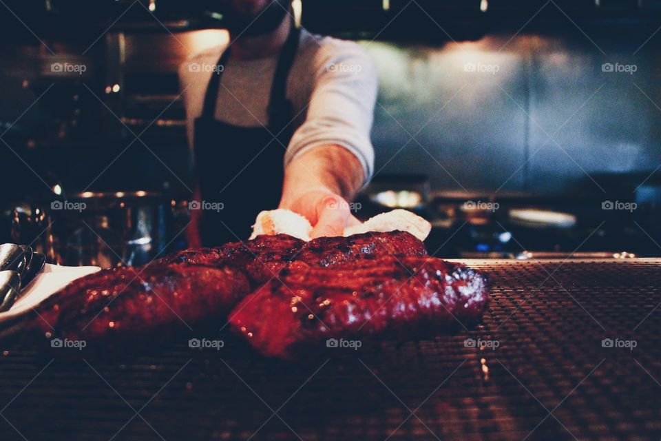 A Chef serves Steak. A Chef presenting a steak straight off the grill