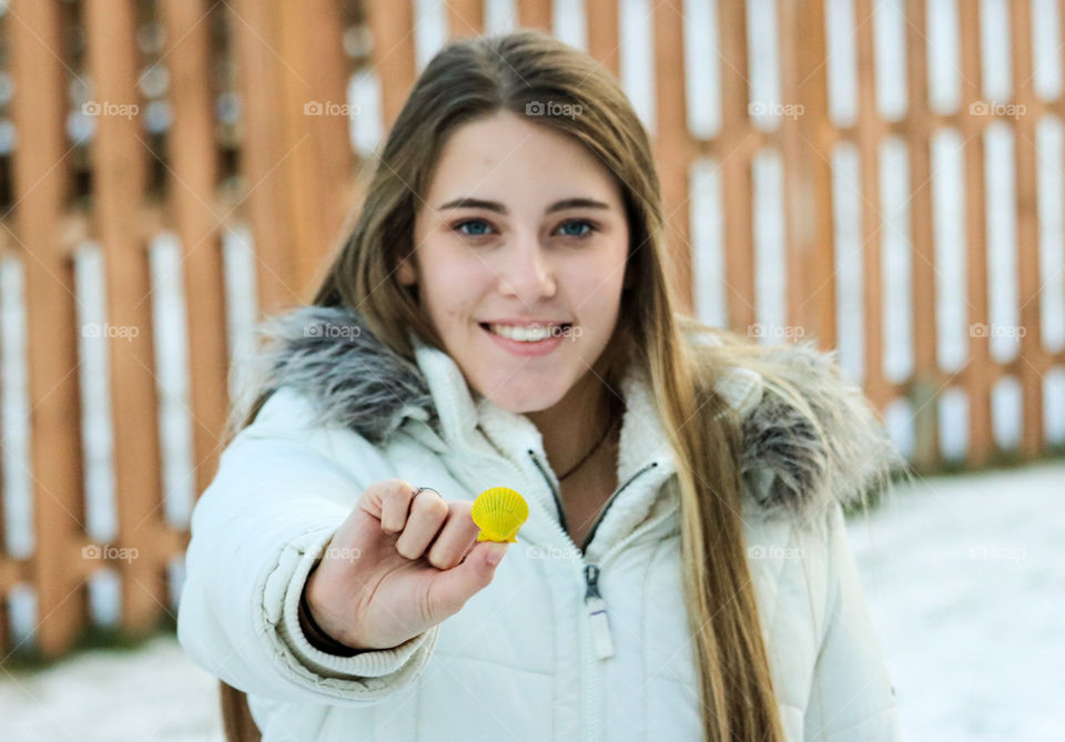 Shell- she's holding a painted yellow scallop shell to represent Shell Gas Stations.