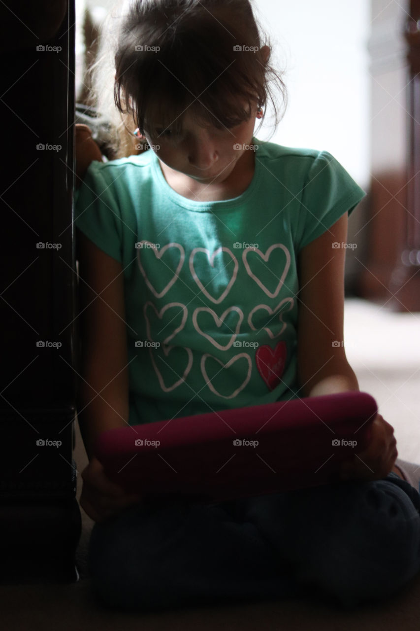 Young child playing on her tablet