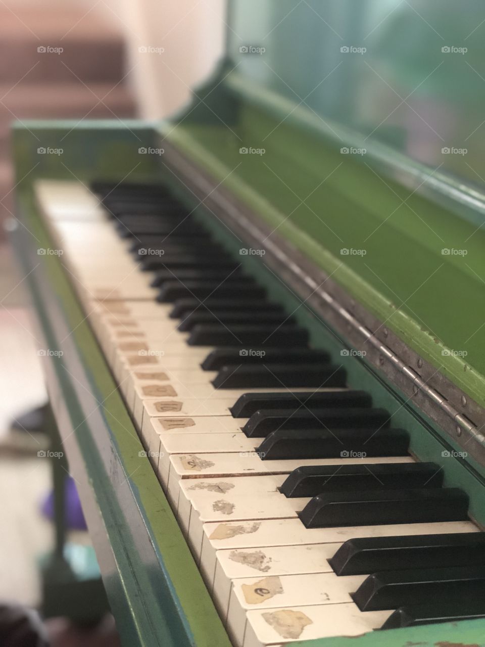 Worn keys on an old piano on an angle