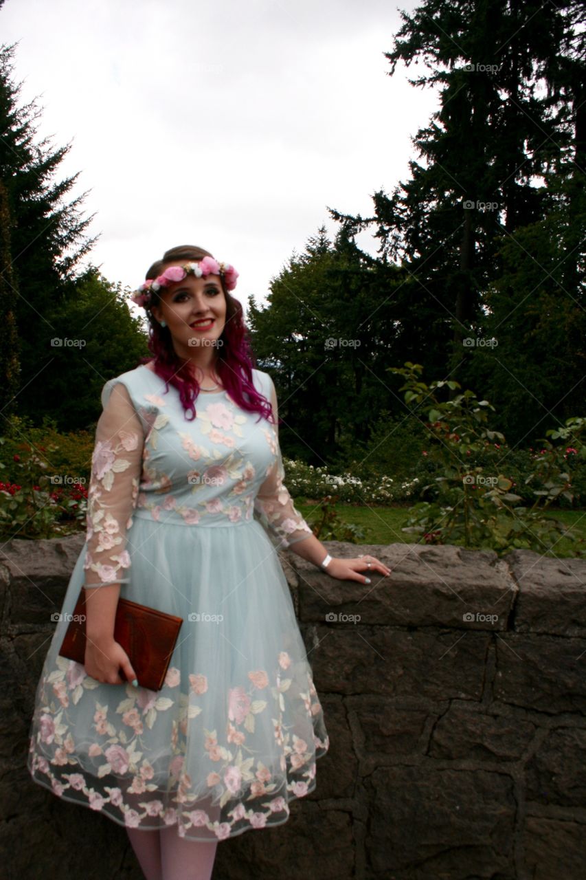 Young woman standing in park with wear crown flower