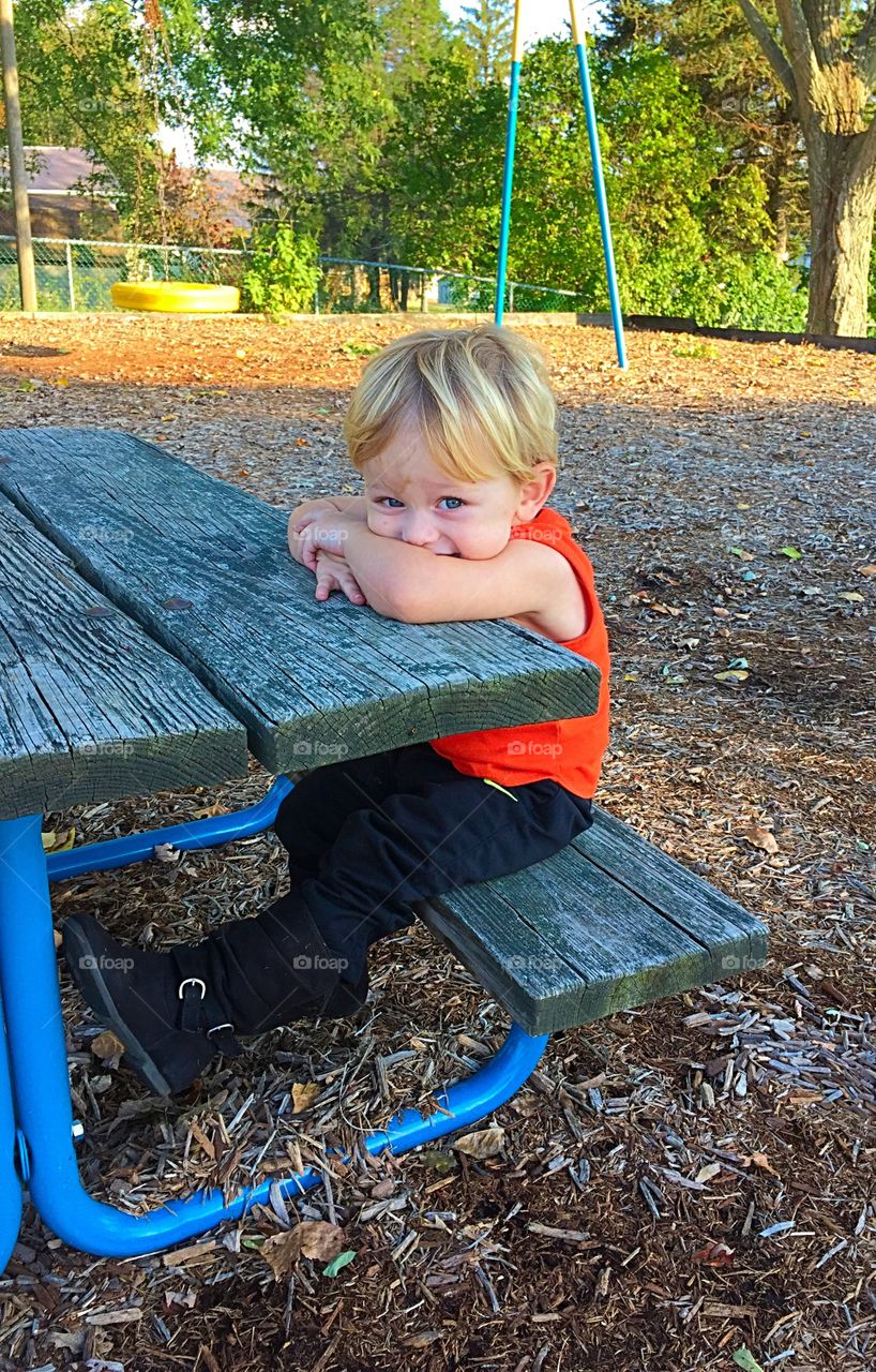 Cute boy sitting on bench