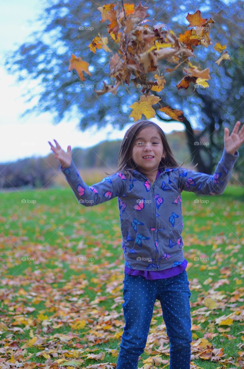 Girl enjoying on grassy field during autumn