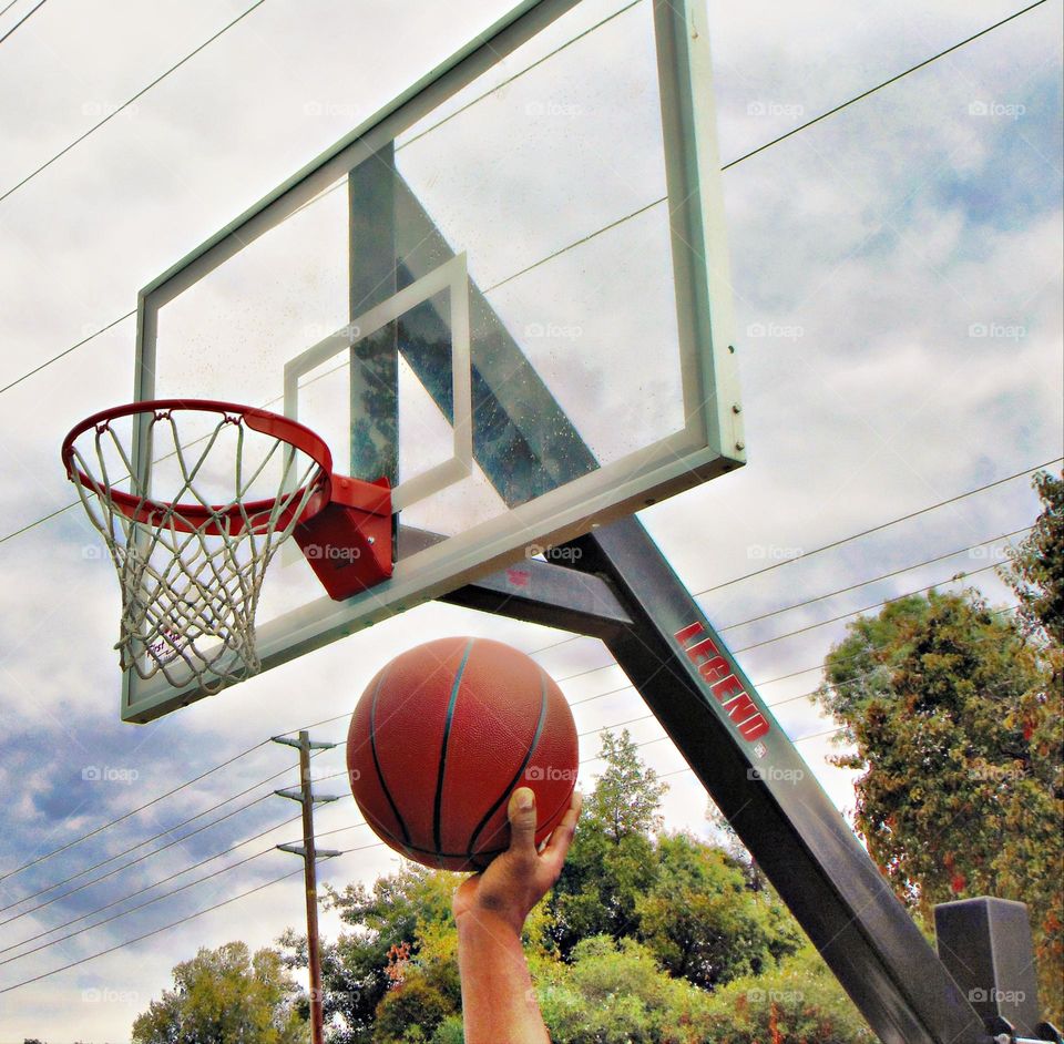 preparing to dunk the ball through the basketball net