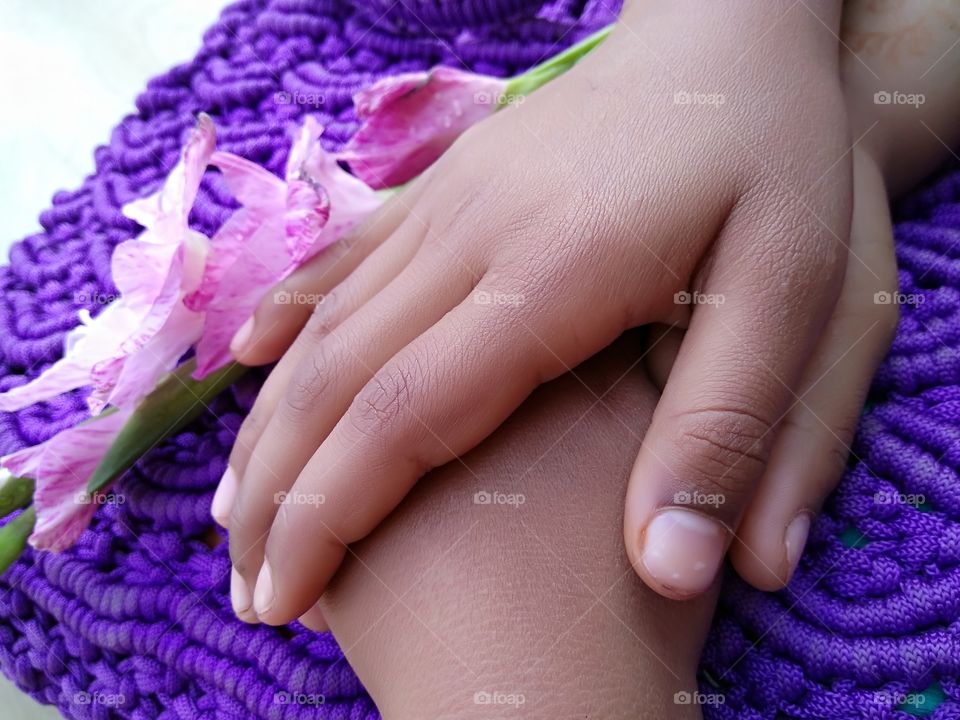Close-up of holding hands near flower