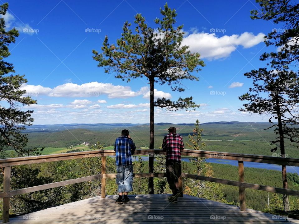 Men watching landscapes in Aavasaks, Lapland, Finland. Aavasaksa is a mountain in Ylitornio, along the Tornionjoki river. Its altitude is 242 meters above sea level.